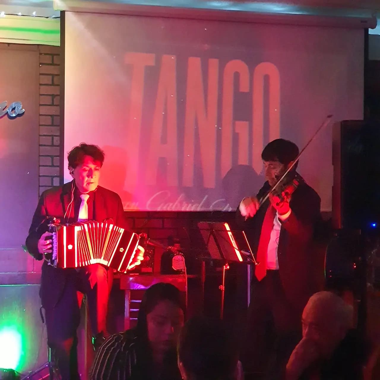 Bandoneonista y violinista durante la noche de tango en El Barítono
